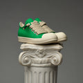 DUAA Green and beige sneakers on a decorative column against a gray background