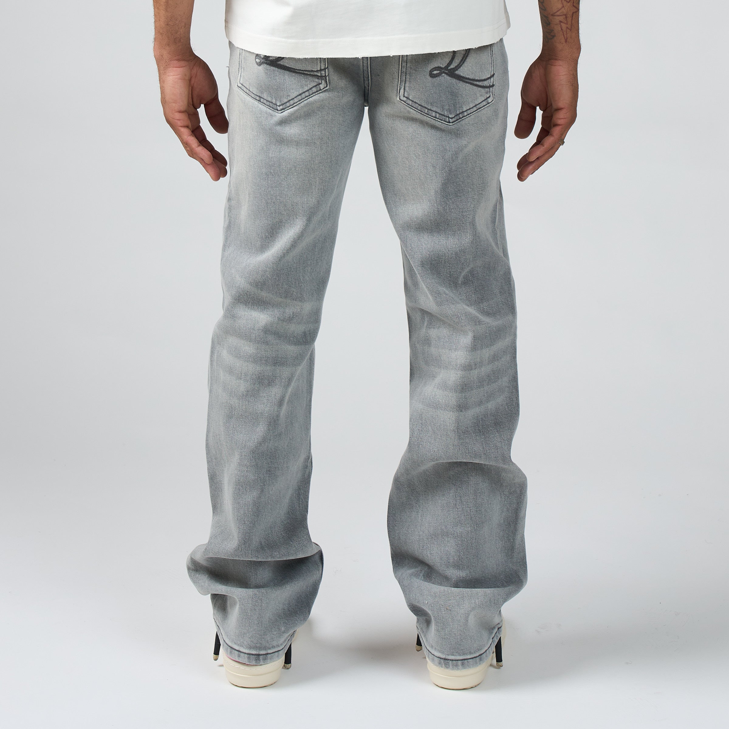 Person wearing DUAA light gray jeans on a white background