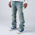 Person wearing DUAA distressed blue jeans and blue sneakers on a white background