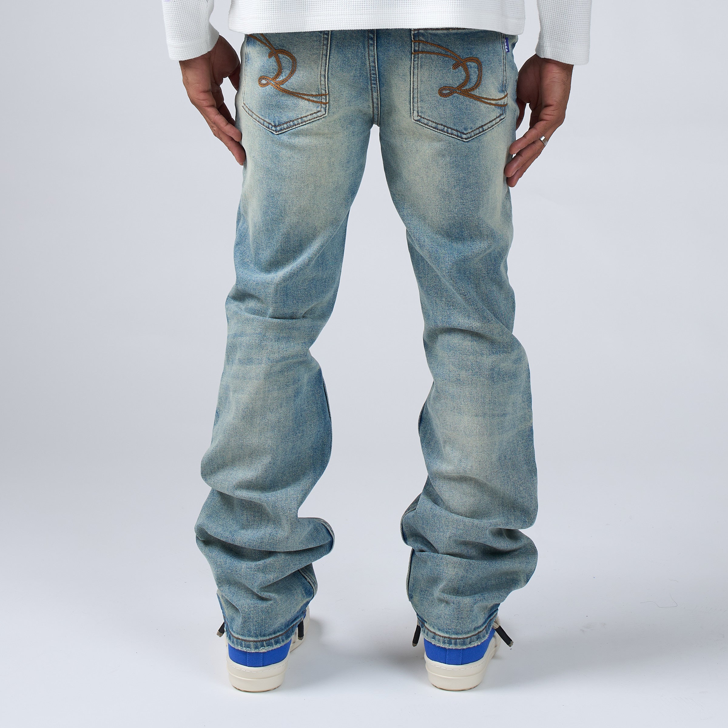 DUAA Blue jeans worn by a person on a white background